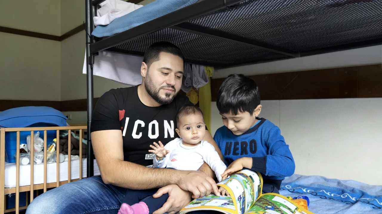 Een vader met zijn kinderen in een asielzoekerscentrum