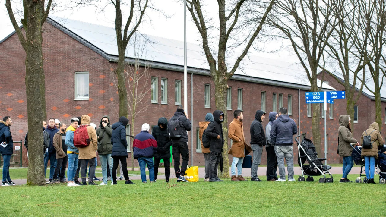 Vluchtelingen wachten buiten bij Ter Apel