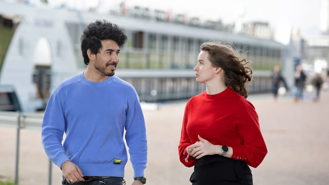 Twee mensen lopen over de Rijnkade