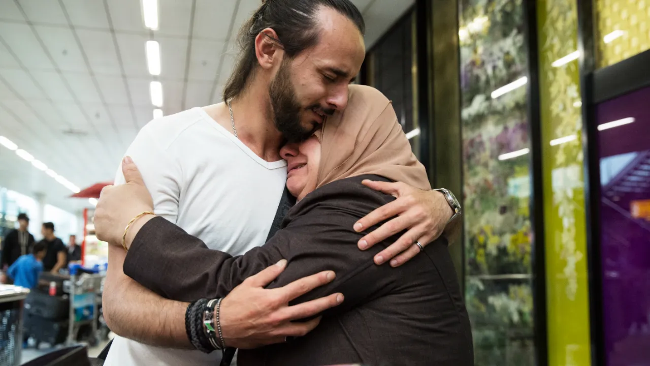 Man en vrouw herenigd op schiphol