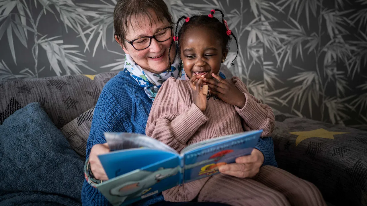 Maatschappelijke begeleider Gerrie leest Lana een verhaaltje voor.