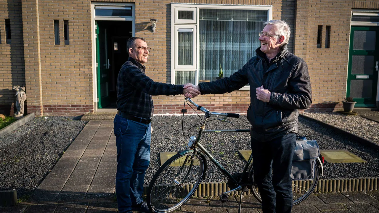 Maatschappelijk begeleider Sjoerd schudt de hand van Mohammed.