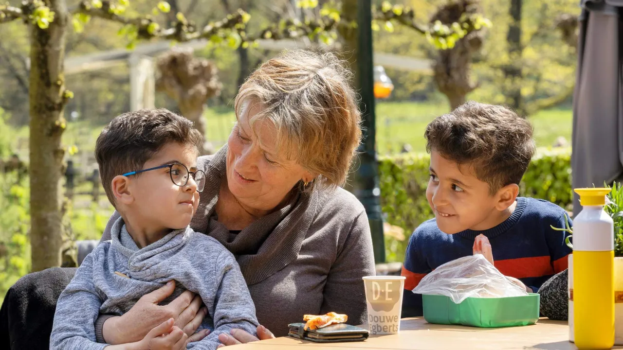 vrijwilliger met kinderen bij het openluchtmuseum