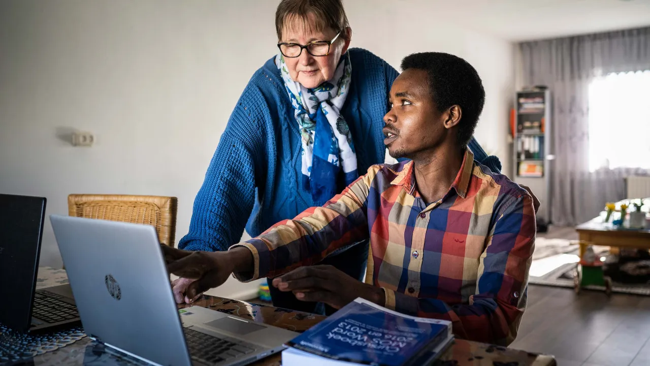 Sabir laat Gerrie iets zien op de computer.