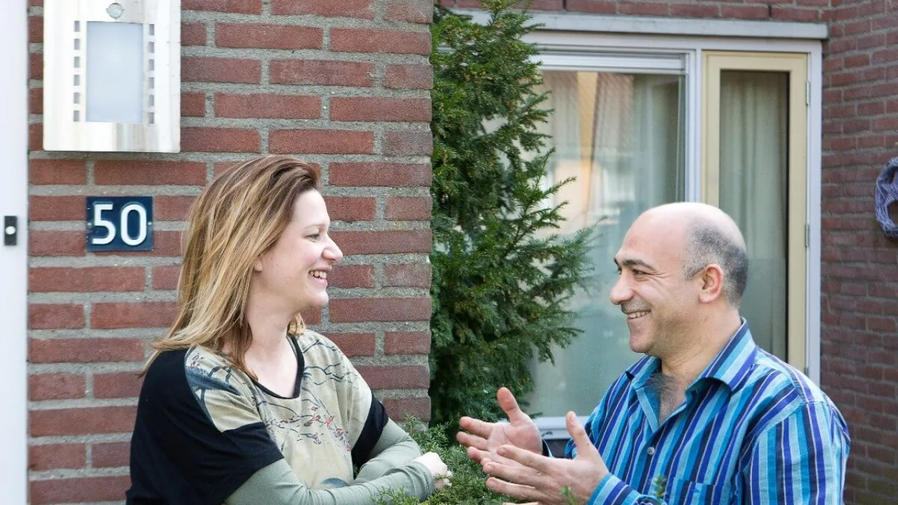 Buren voeren gesprek over een heg