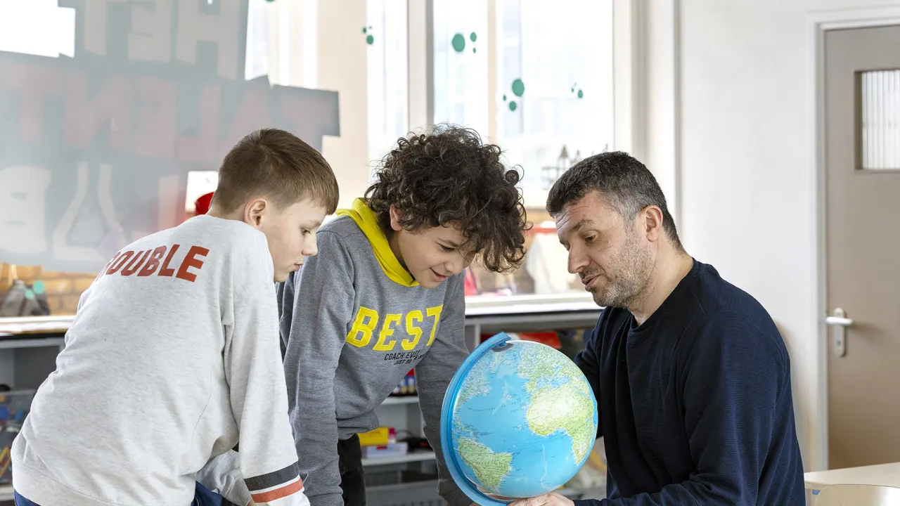 Vluchteling Bekir en kinderen met wereldbol 