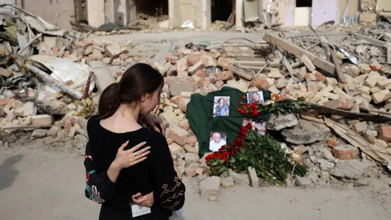 Mensen rouwen bij een gebombardeerd kinderziekenhuis in Kyiv