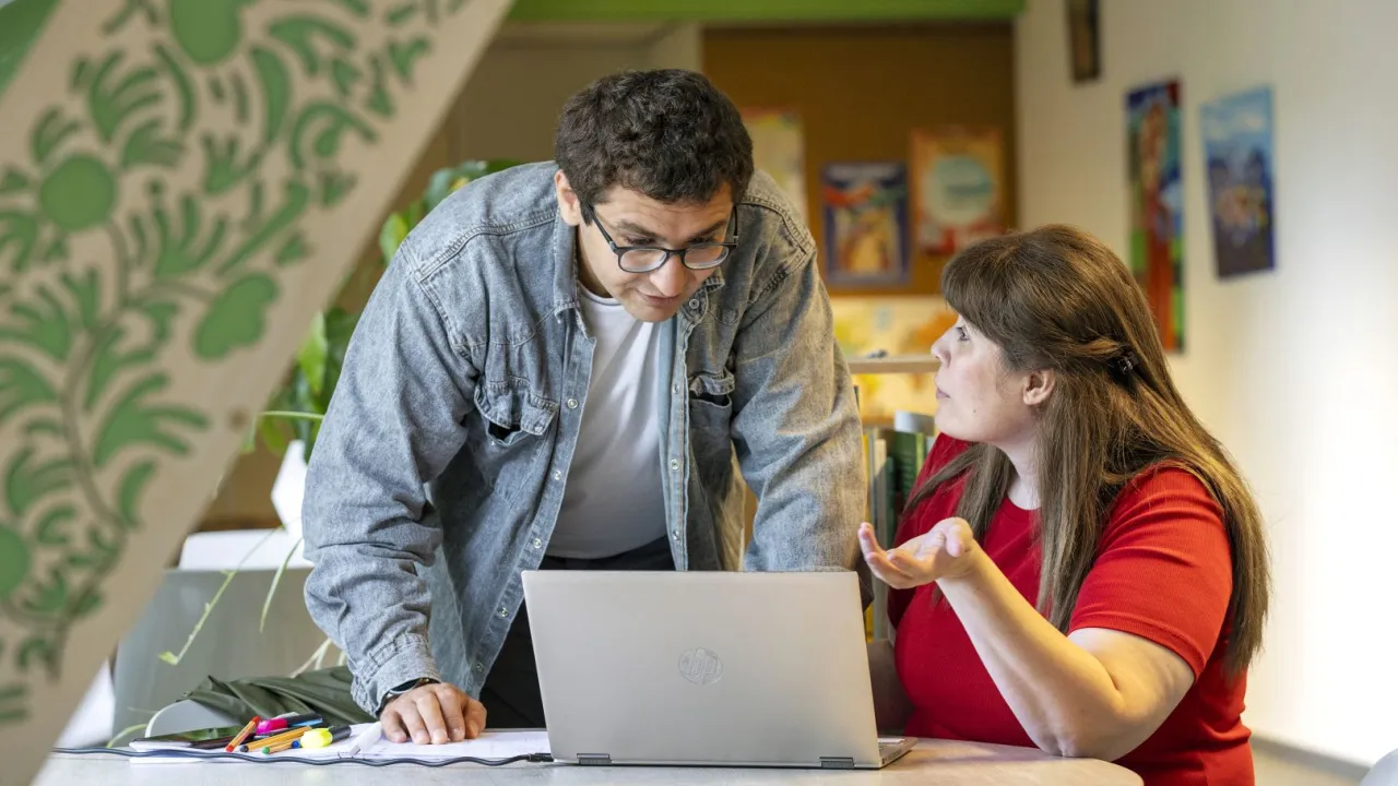 Vrijwilliger toont vluchteling cijfers op laptop