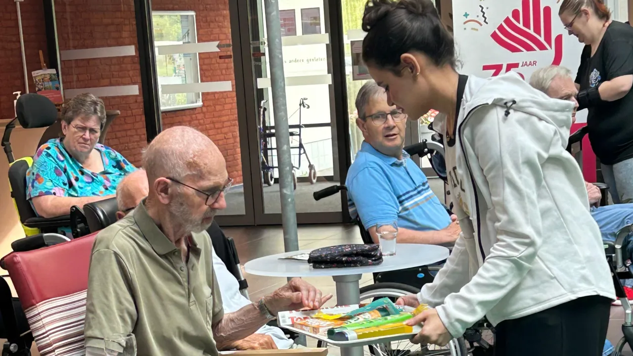 Meisje biedt koekje aan oudere man
