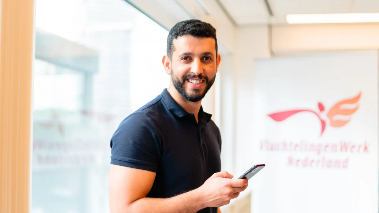 Man met telefoon bij VluchtelingenWerk Nederland