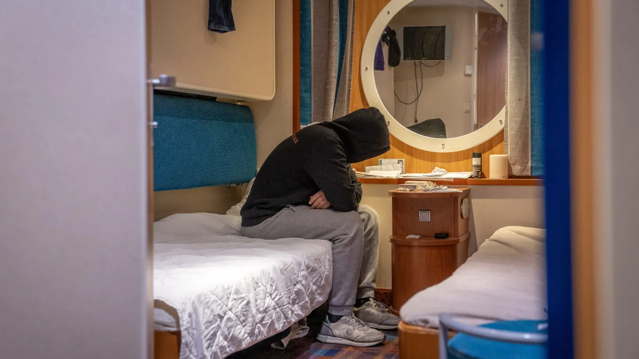 Man in kamer van de MS Galaxy in Amsterdam