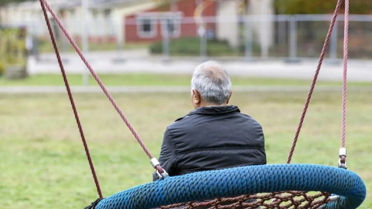 Man op schommel bij opvangplek