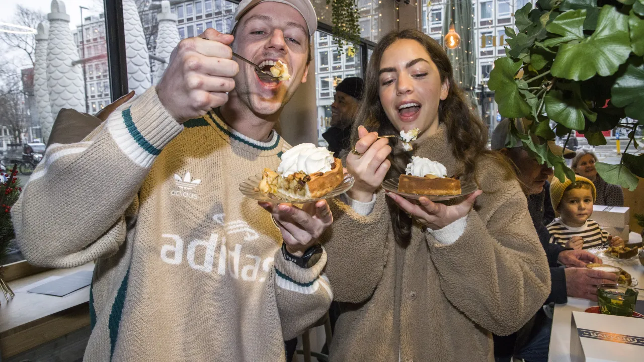 Twee mensen eten Ter Apeltaart bij Bakkerij van Waarde