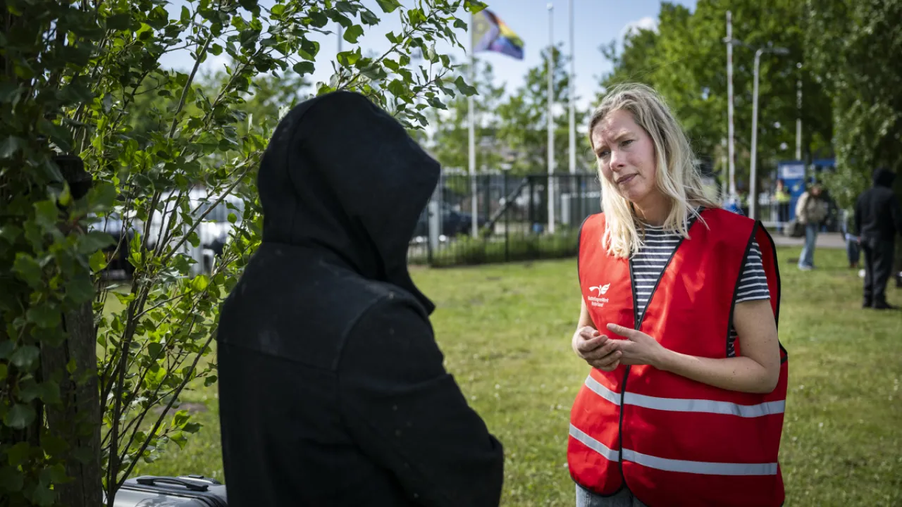 Een medewerker van VluchtelingenWerk praat met een asielzoeker bij Ter Apel