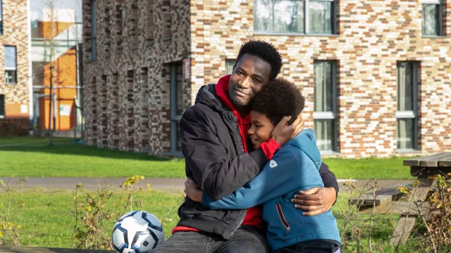 Batou en Mamadou op een bankje buiten de opvang