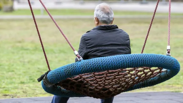Man op schommel bij opvangplek