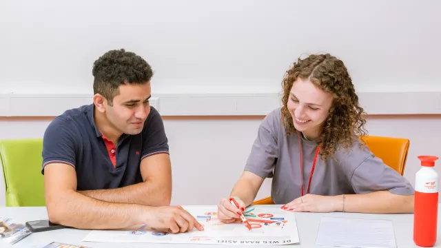 Vrijwilliger legt informatie uit aan vluchteling 