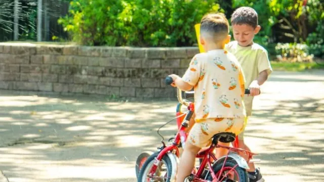 Vluchtelingenkinderen spelen buiten op een fietsje