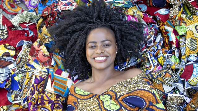 Vrouw van bovenaf, ligt op kleurrijke stoffen