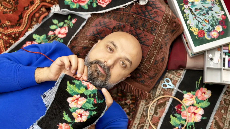 Foto van Hazem met zijn borduurwerk