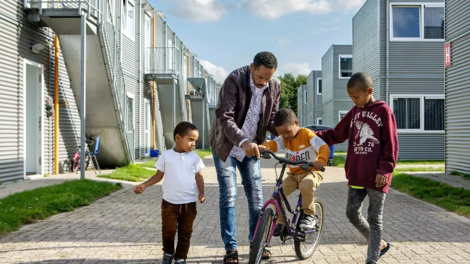 Vader leert kinderen fietsen voor woning - AZC