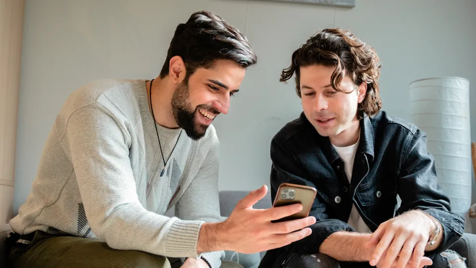 Twee mannen kijken op telefoon