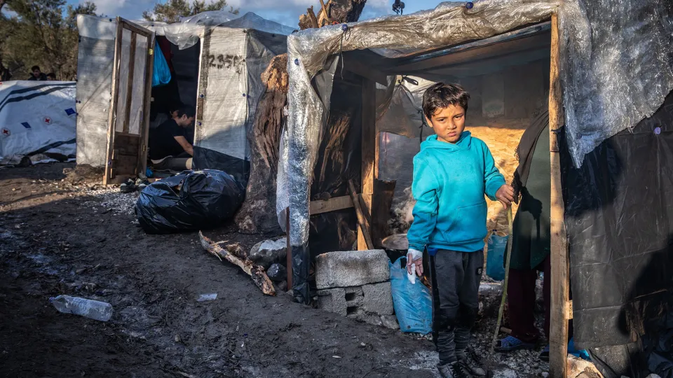 Een jongetje staat in kamp Moira, Griekenland