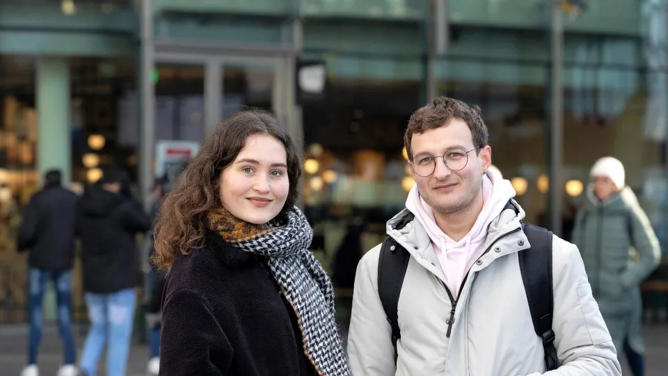 Een jonge man en vrouw kijken in de camera - coverbeeld jaarverslag VluchtelingenWerk 2023 