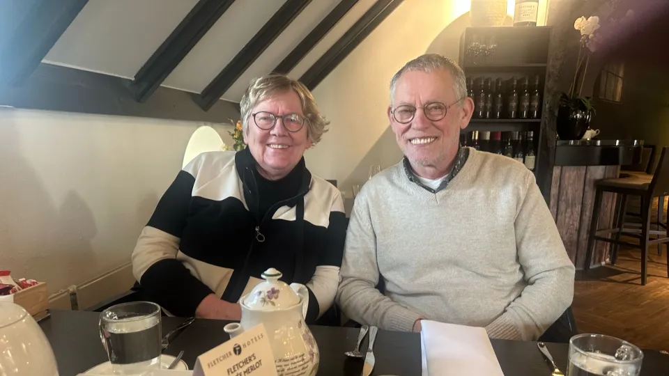 Vrijwilligers Gert Jan en Greet van VluchtelingenWerk aan tafel