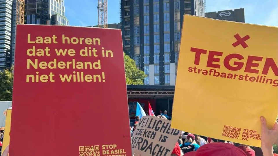 Twee borden op de demonstratie tegen de asielwetten en strafbaarstelling illegaliteit