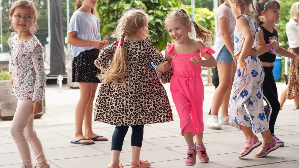 Kinderen dansen op het kindervakantiefestival van VluchtelingenWerk