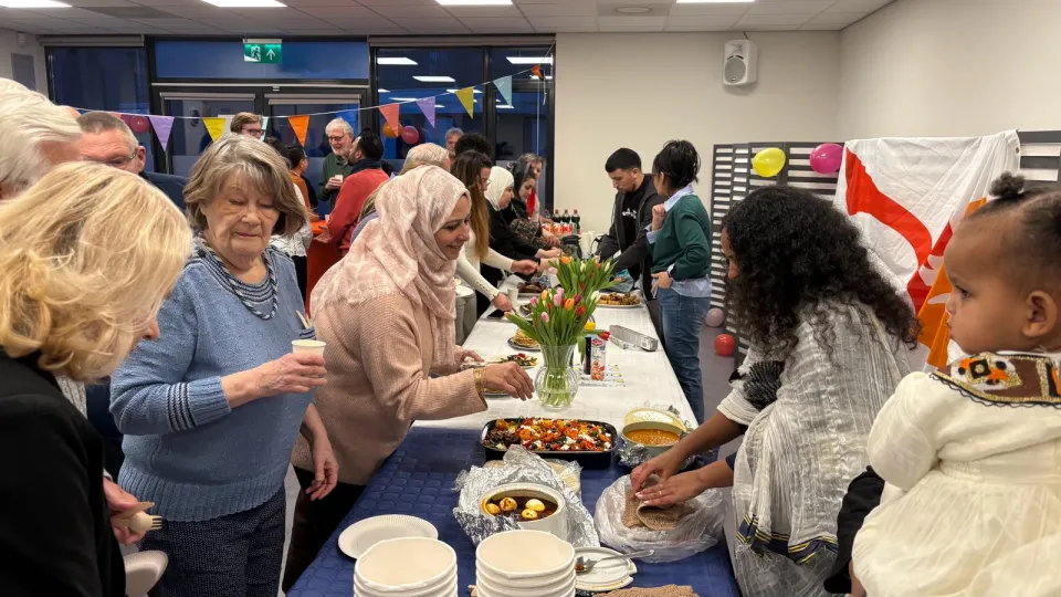 Inwoners van Schoonhoven eten samen met mensen met een vluchtachtergrond tijdens een Samen Eten-event van VluchtelingenWerk Nederland. 