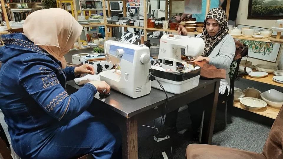 Twee vrouwen naaien samen in een naaiatelier