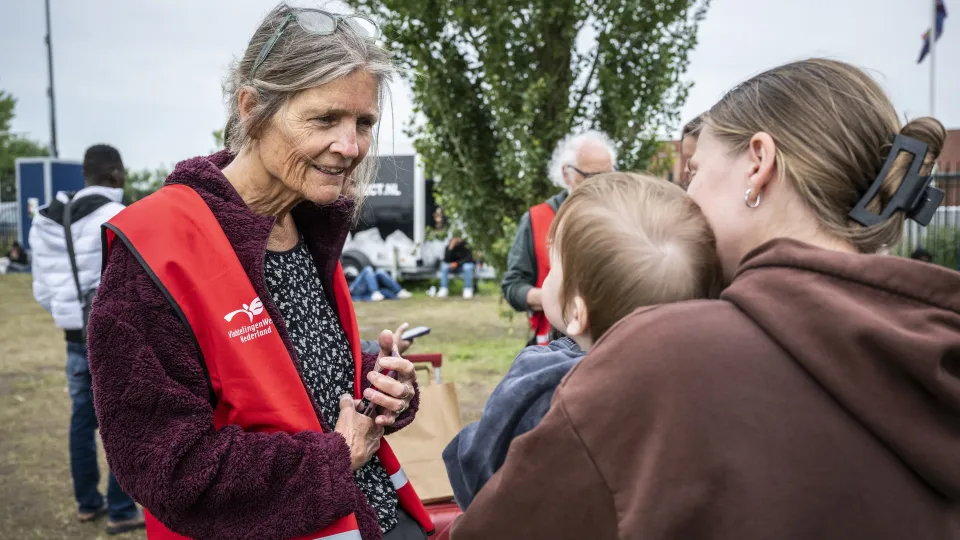 Vrijwilliger Rode Kruis helpt vrouw en kind in Ter Apel