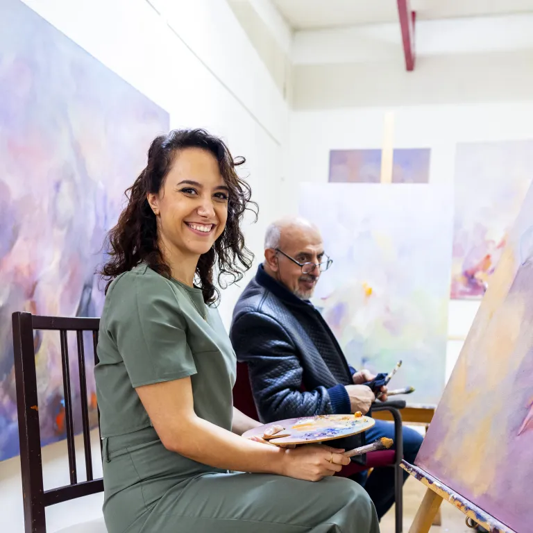 Vluchteling Hala en haar vader aan het schilderen