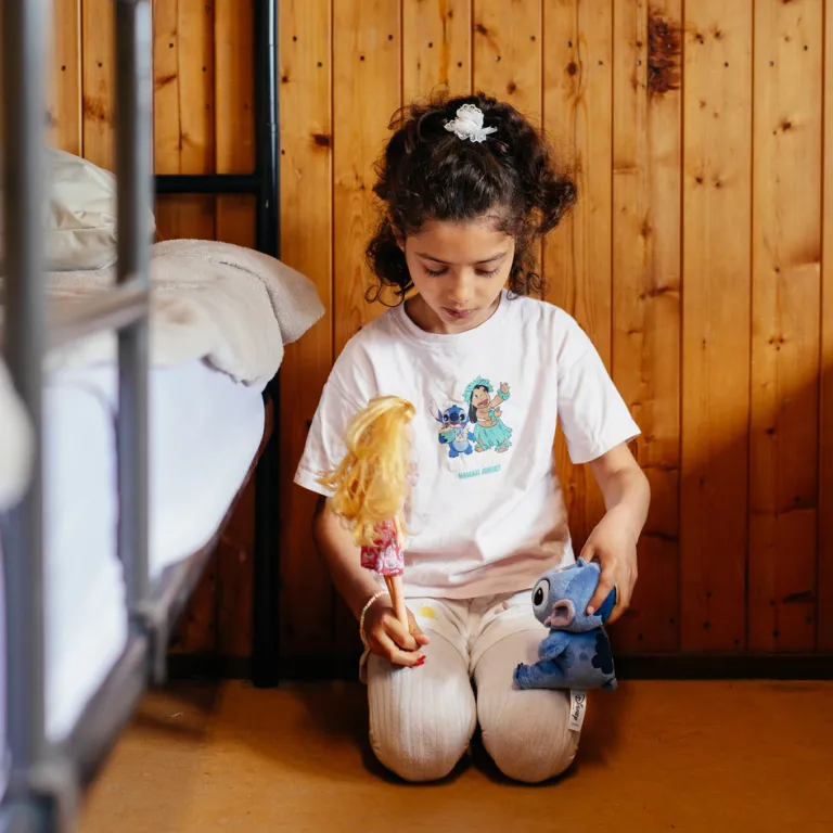 Aisha speelt in de noodopvang met haar barbies