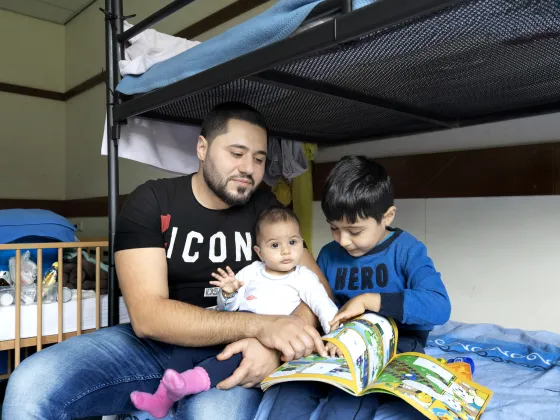 Een vader met zijn kinderen in een asielzoekerscentrum