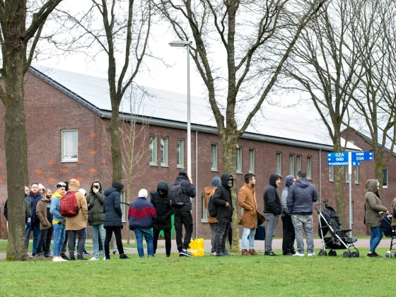 Vluchtelingen wachten buiten bij Ter Apel