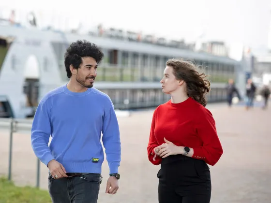 Twee mensen lopen over de Rijnkade