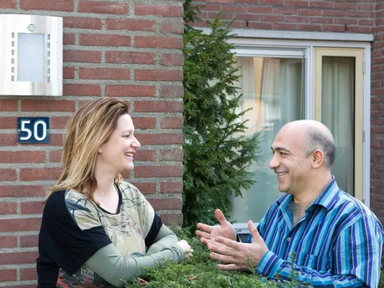 Buren voeren gesprek over een heg