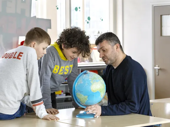 Vluchteling Bekir en kinderen met wereldbol 