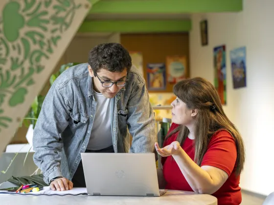 Vrijwilliger toont vluchteling cijfers op laptop