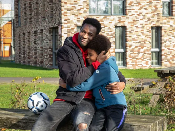 Batou en Mamadou op een bankje buiten de opvang