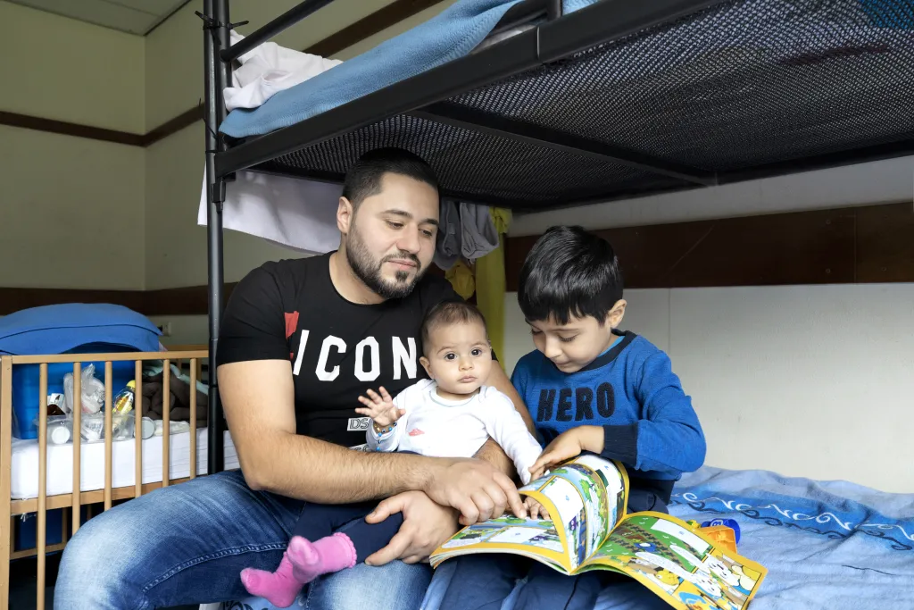 Een vader met zijn kinderen in een asielzoekerscentrum