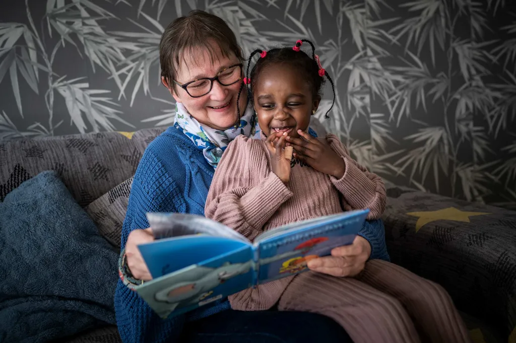 Maatschappelijke begeleider Gerrie leest Lana een verhaaltje voor.