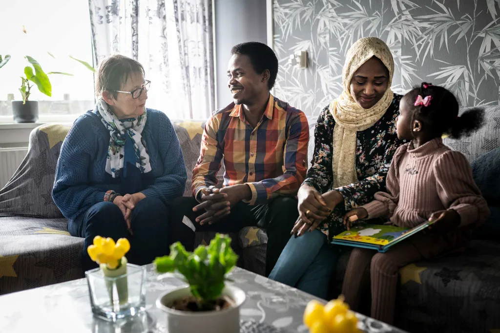 Maatschappelijke begeleider Gerrie en Sabir en Rawda in de woonkamer