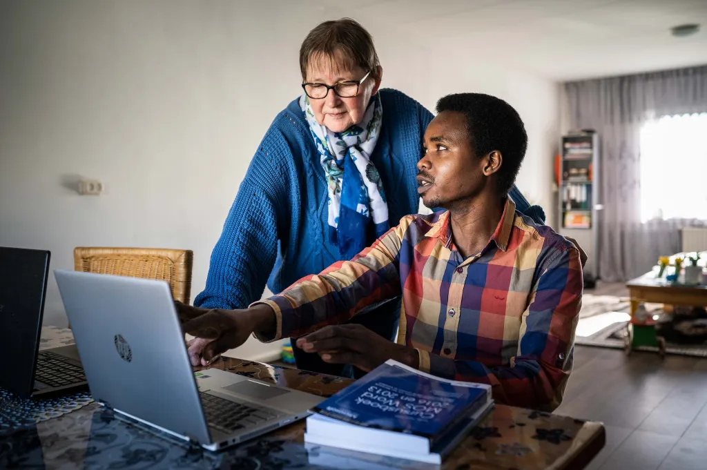 Sabir laat Gerrie iets zien op de computer.