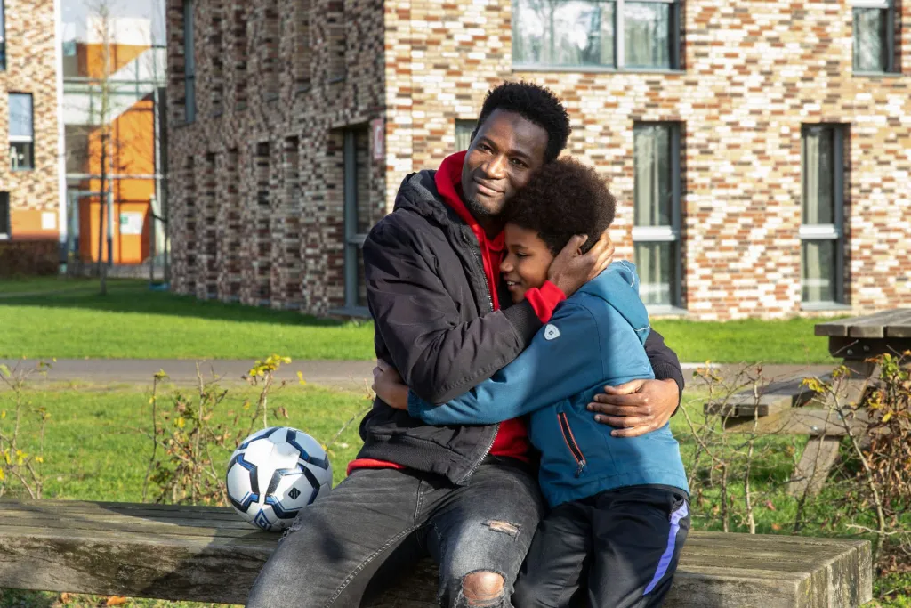 Batou en Mamadou op een bankje buiten de opvang