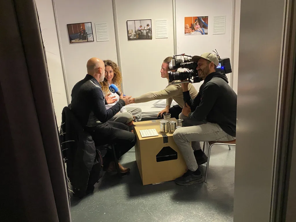 Katja Schuurman en de Syrische Alaa worden geïnterviewd door Shownieuws in Hotel AZC