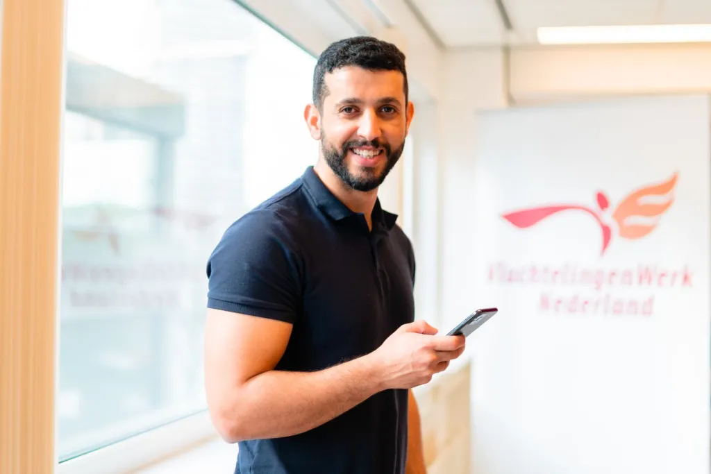 Man met telefoon bij VluchtelingenWerk Nederland